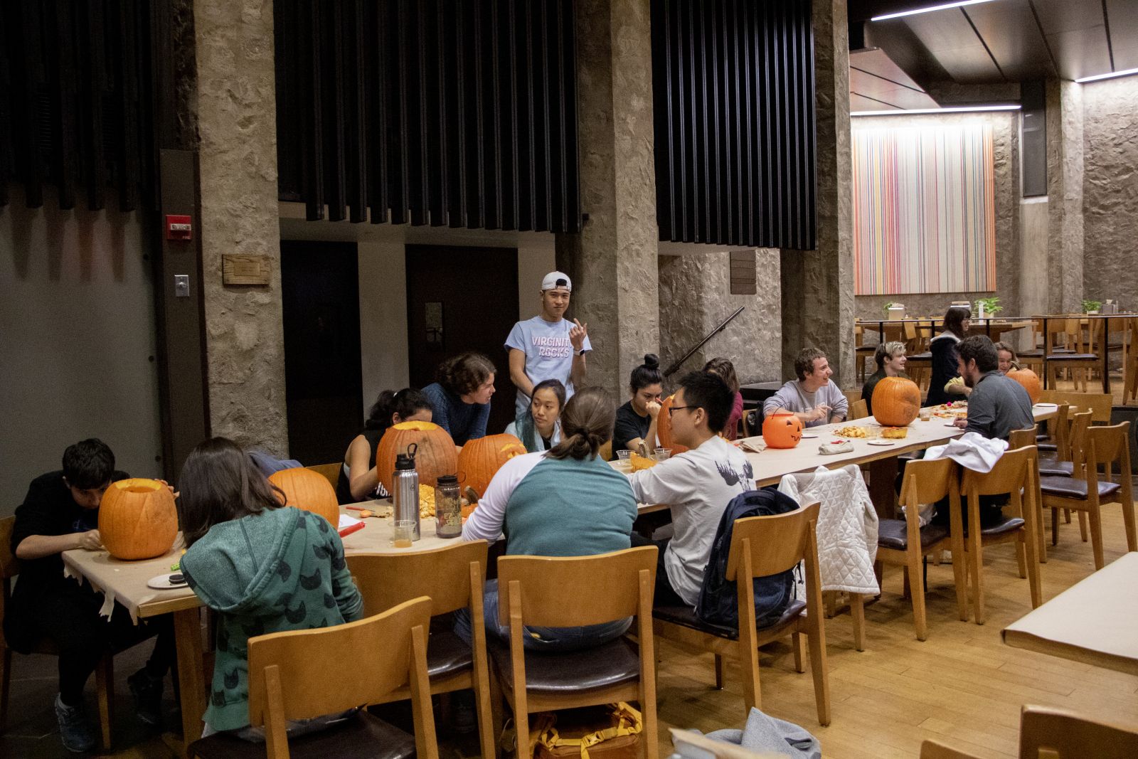 A table full of yale students carving out their designs on pumpkins