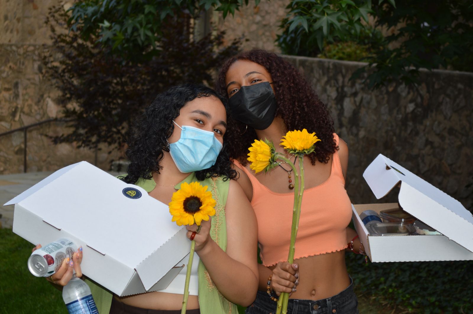 2 students with snacks from the picnic for first-year and second-year students