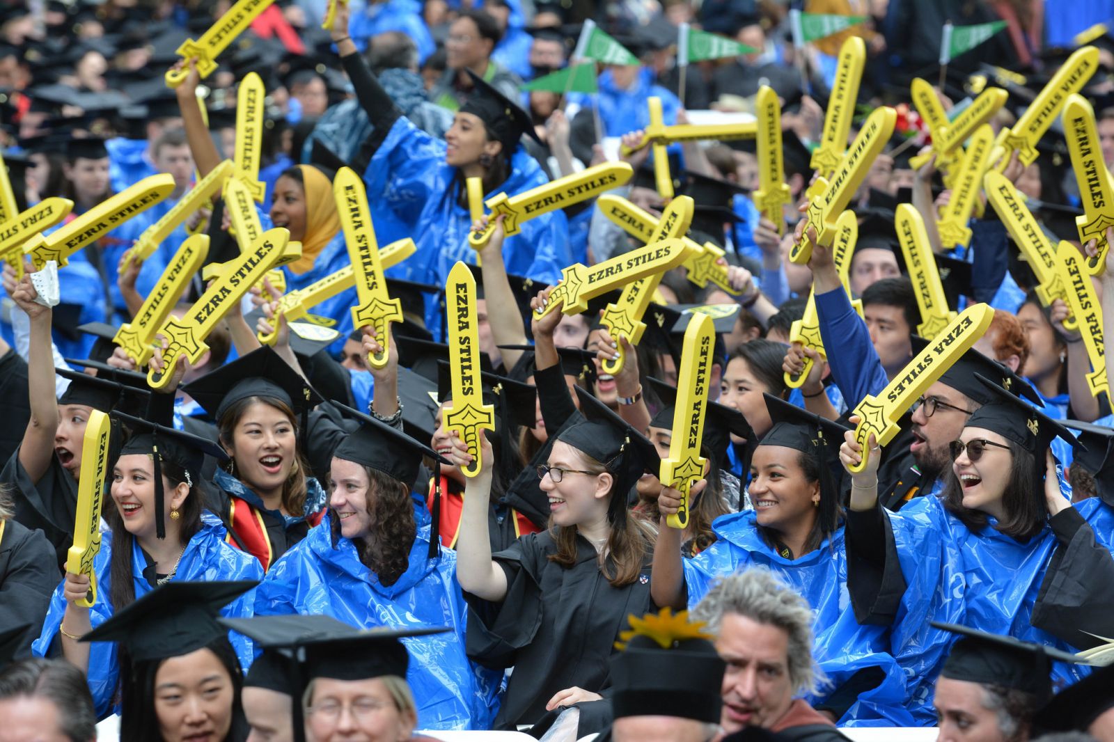 Graduating students wave their Ezra Stiles swords in the air