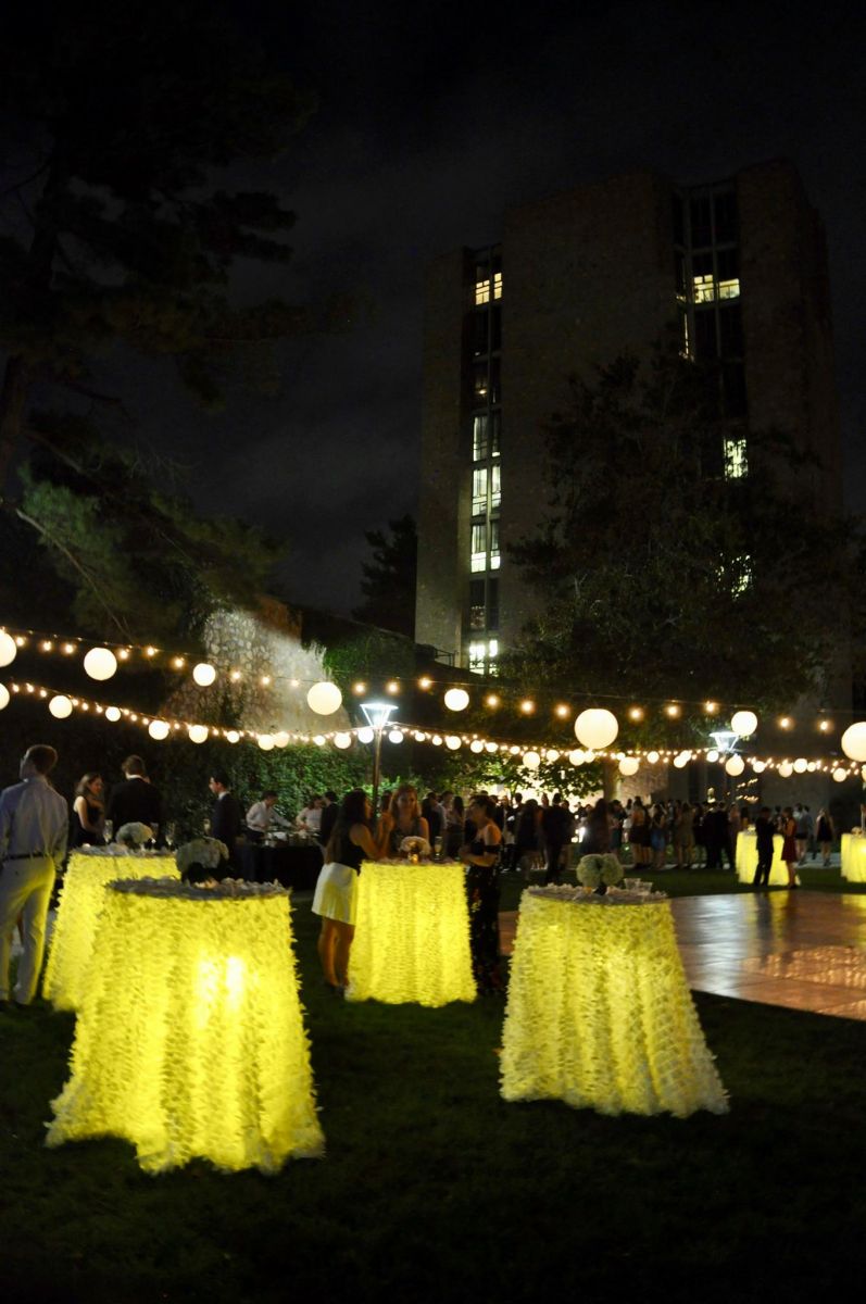 Yellow covers on small tables and a dance floor at the courtyard