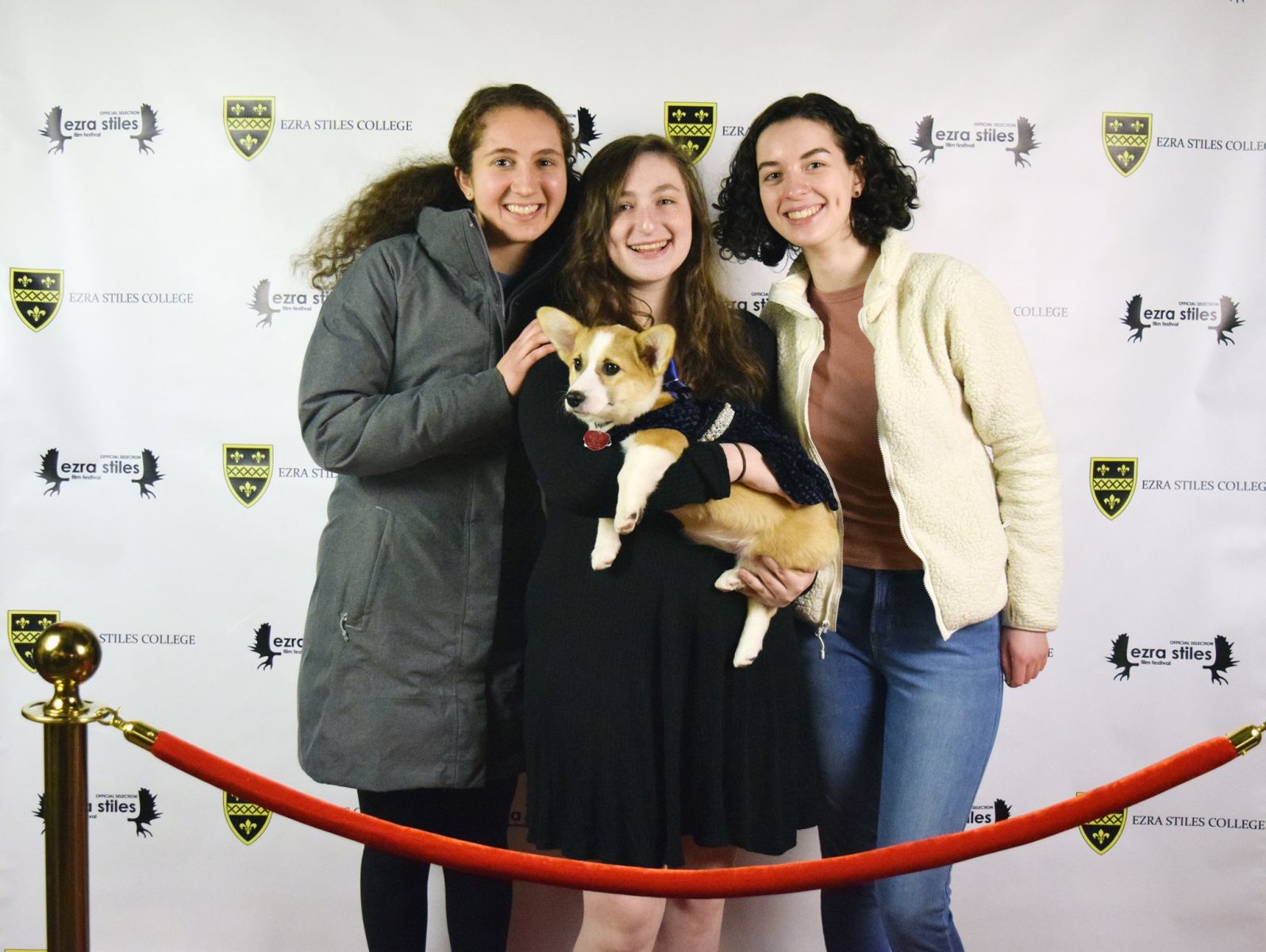 3 Yale students taking a photo with the corgi named Coco