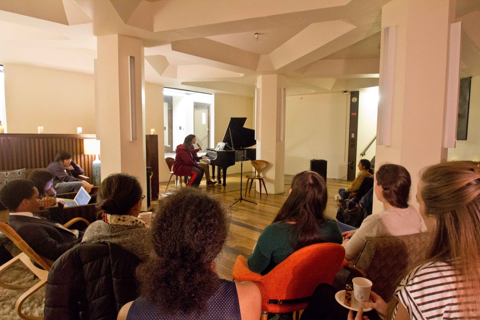 A lady plays on the piano for the open mic coffeehouse