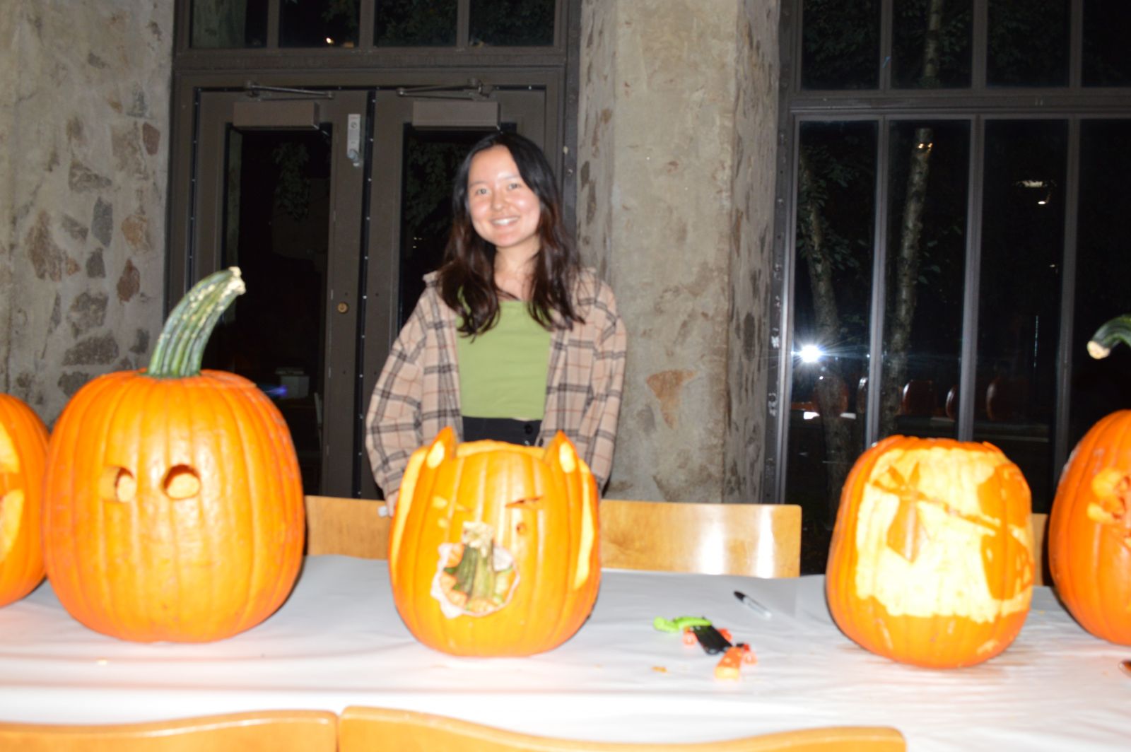 Yale student takes picture with their carved pumpkin