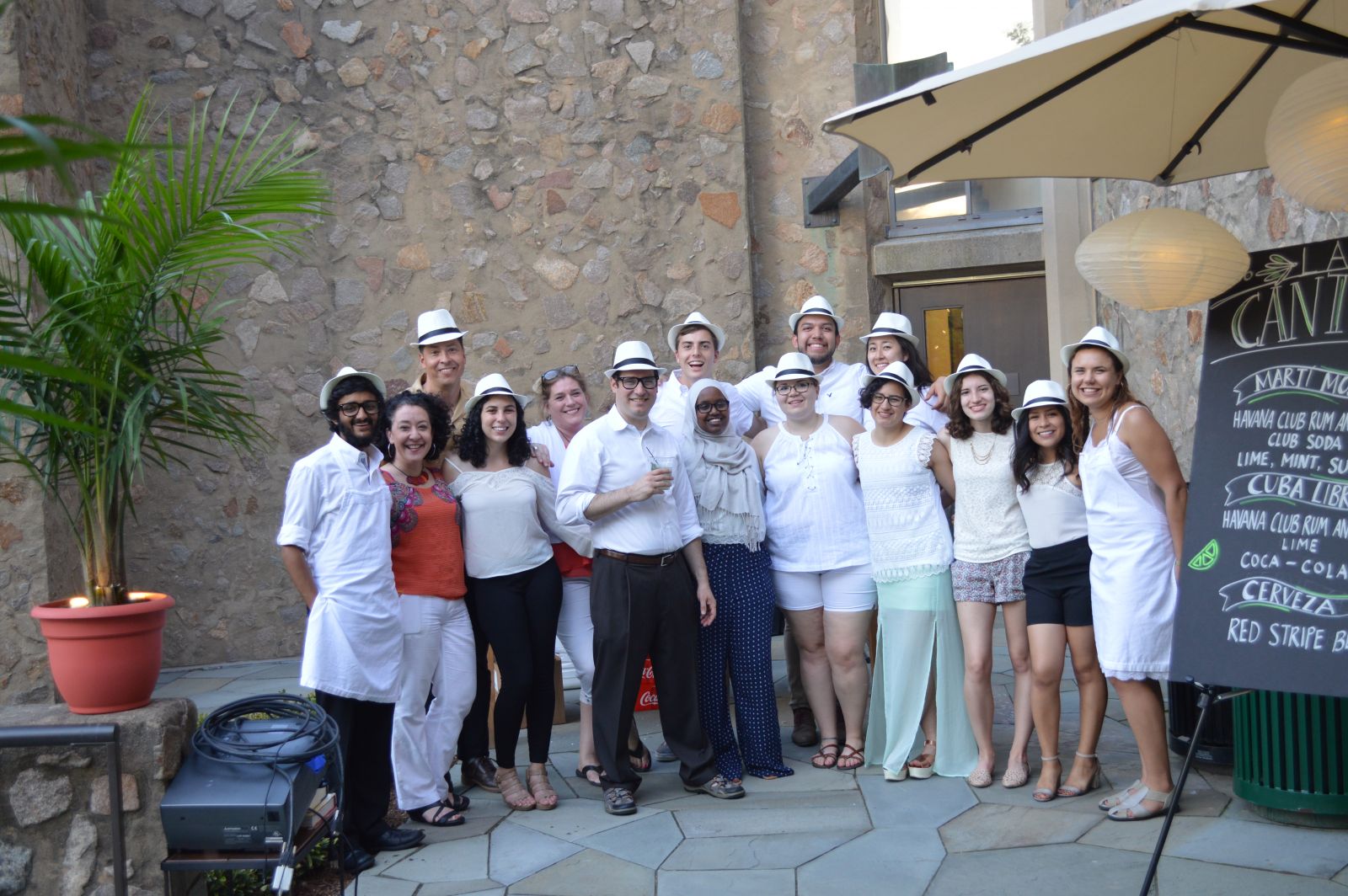 Students dressed in white fedoras, white shirts, and dress pants