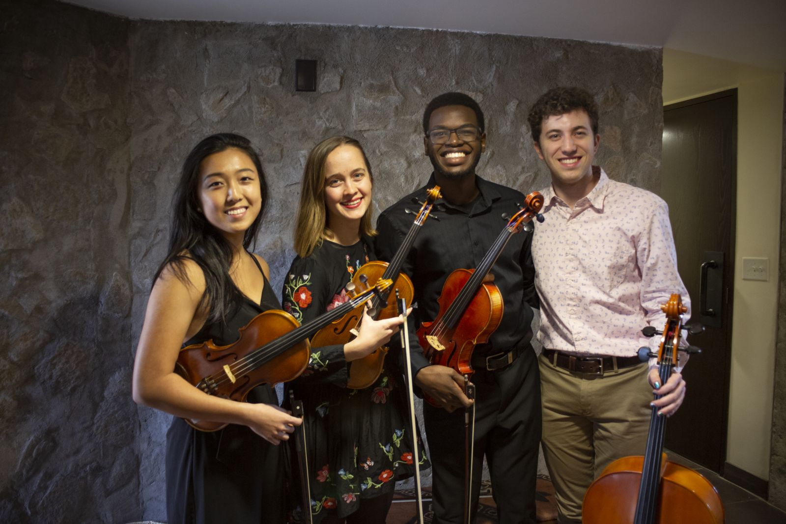 4 Yale students holding their violins
