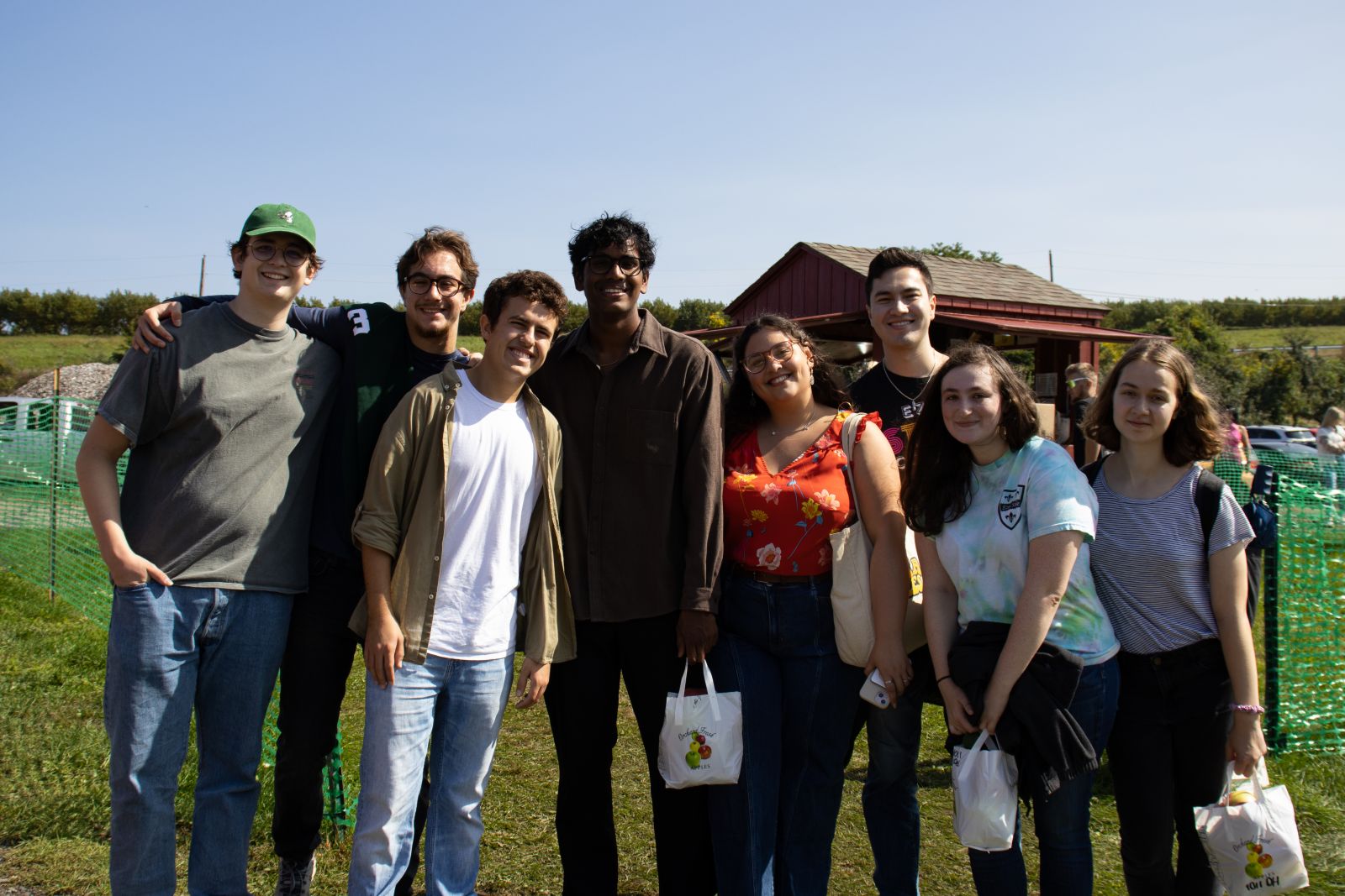 Group of 8 in front of the orchard stand