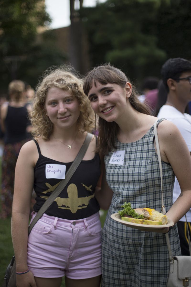 2 students enjoying the warm weather and the cookout