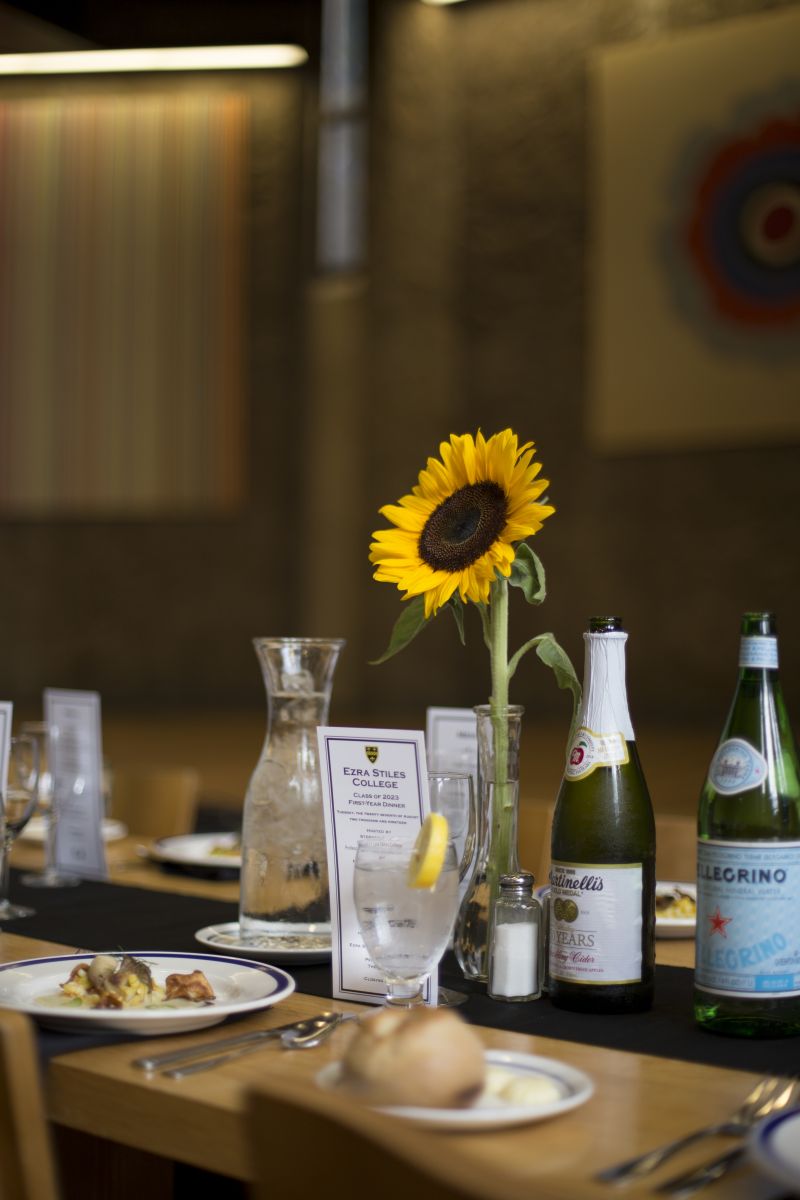 The first-year dining table designed with a flower, a small menu and sparkling water