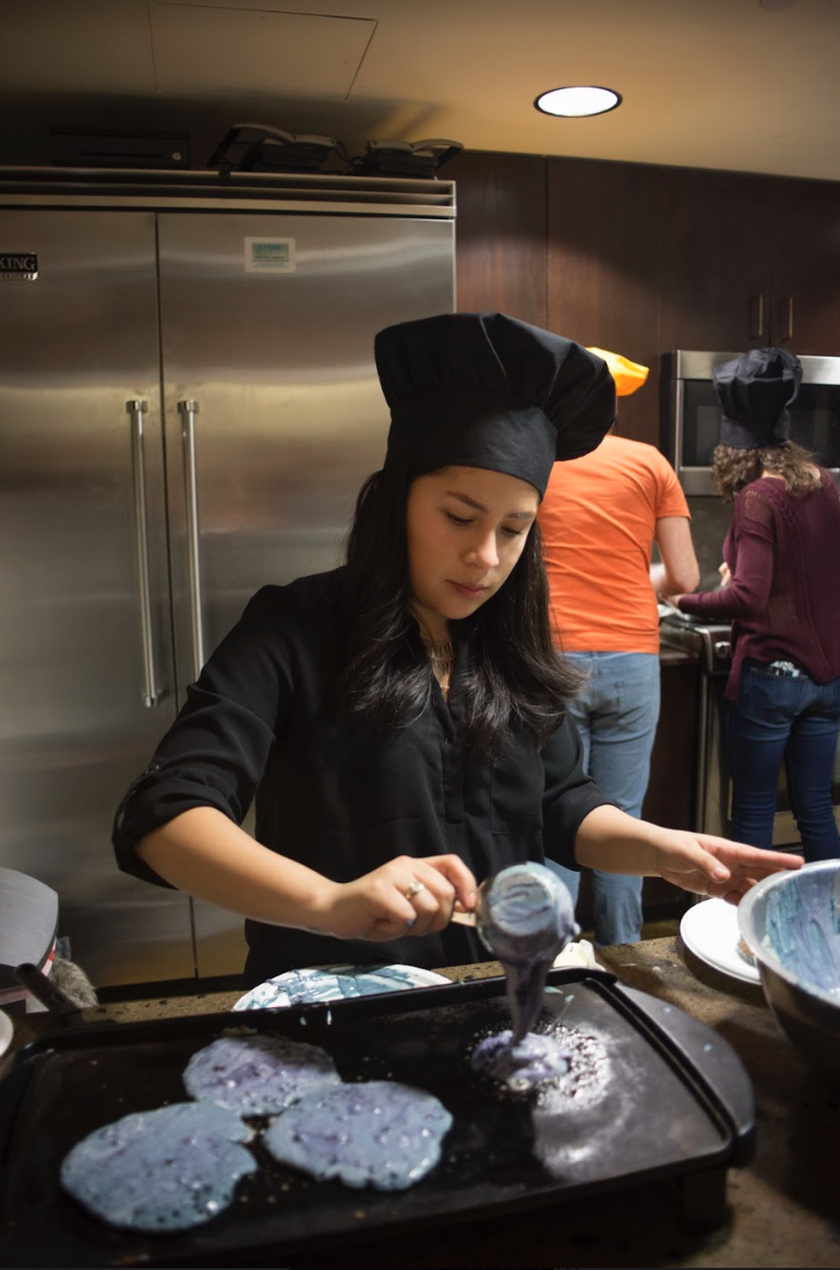 An SAC member makes some purple-colored pancakes