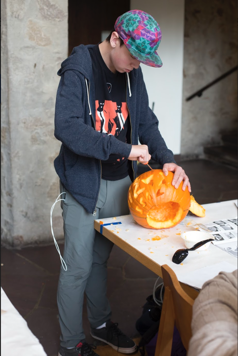 A student carving their pumpkin with full focus