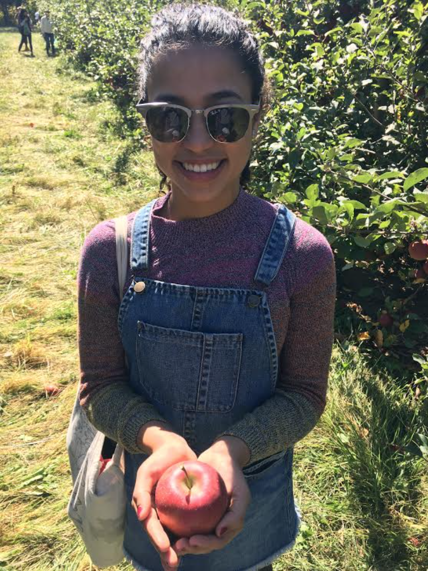 A student holds a red apple they picked from the orchard