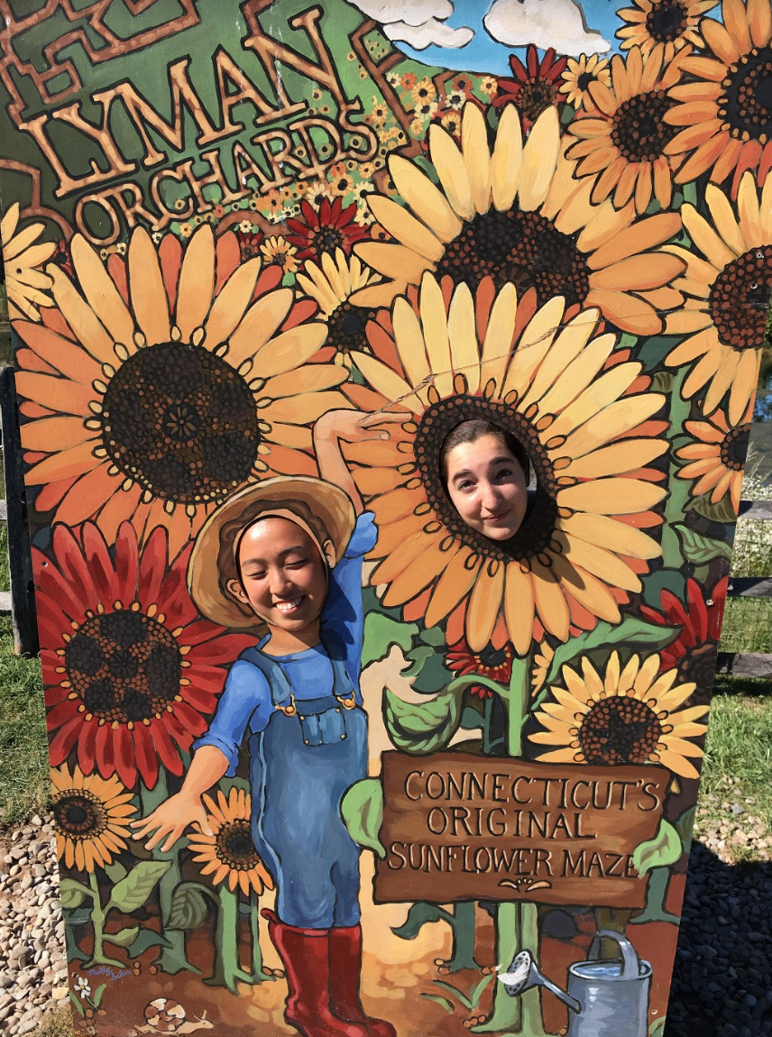 Students take pictures in the cutout Lyman Orchards sign