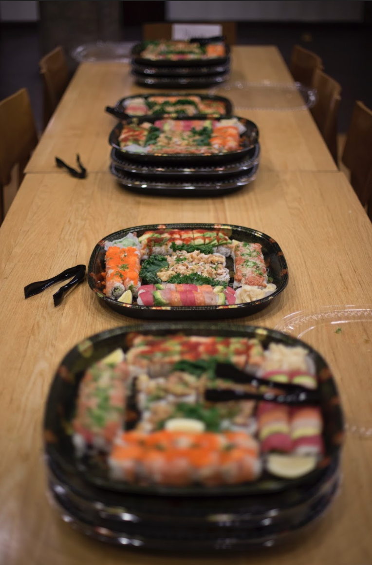 Small trays full of sushi across the table