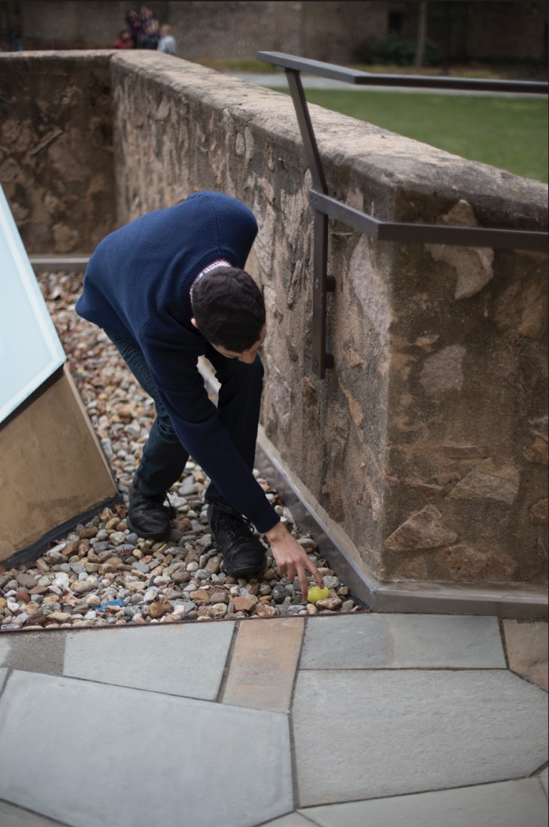 A senior finds a yellow egg on the ground at the courtyard