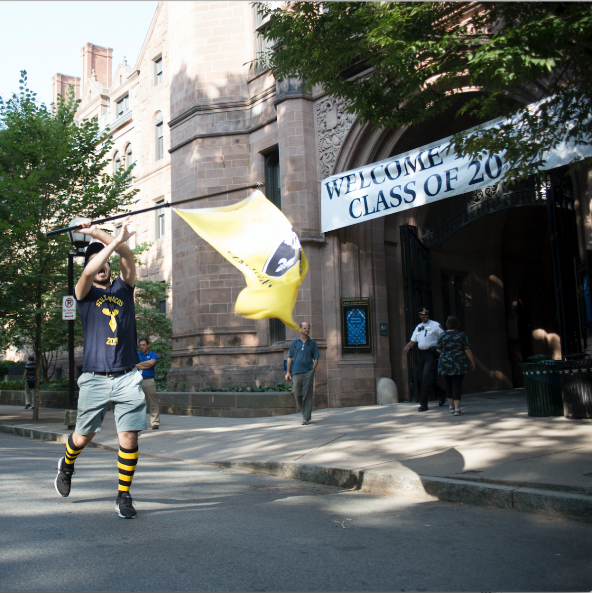 Yale student waves around the Ezra Stiles flag in front of the Welcome entrance