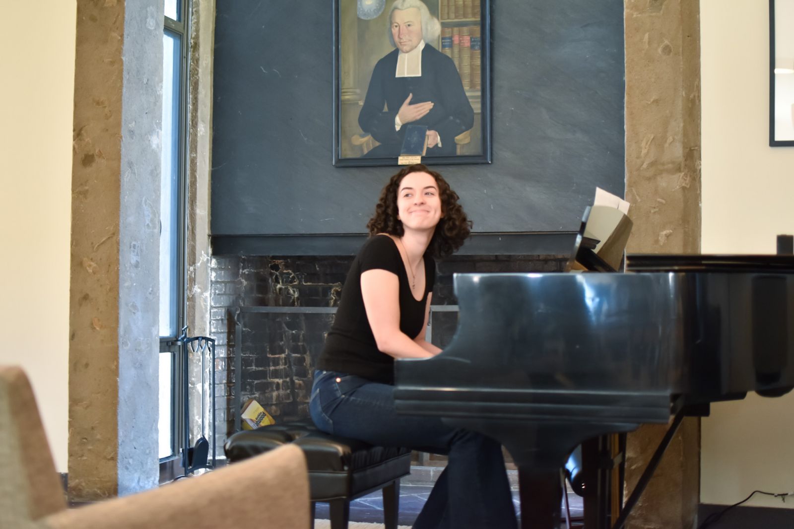 Lady playing the piano in Ezra Stile common room