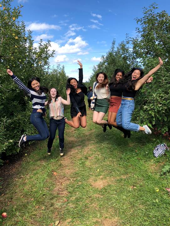 6 students in the air happy to be at the orchard