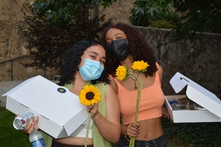 2 students with snacks from the picnic for first-year and second-year students