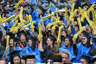 Graduating students wave their Ezra Stiles swords in the air