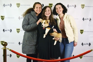 3 Yale students taking a photo with the corgi named Coco