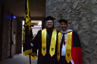 Commencement 2023 with a Stilesian valedictorian holding the college flag