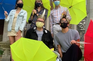 A group of 5 friends with blue, yellow, and red umbrellas and viking hats