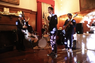 A jazz band playing the saxophone, violin, and guitar