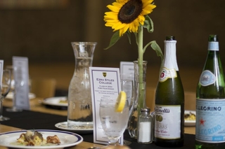 The first-year dining table designed with a flower, a small menu and sparkling water