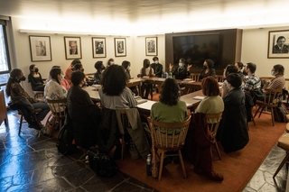 Limon in the Fellow Lounge having a discussion with a full room of people
