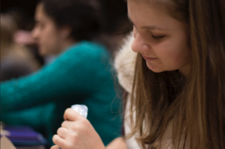 A student puts frosting on their cookie