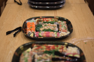 Small trays full of sushi across the table