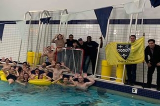 The water polo team posing for the photo in the pool
